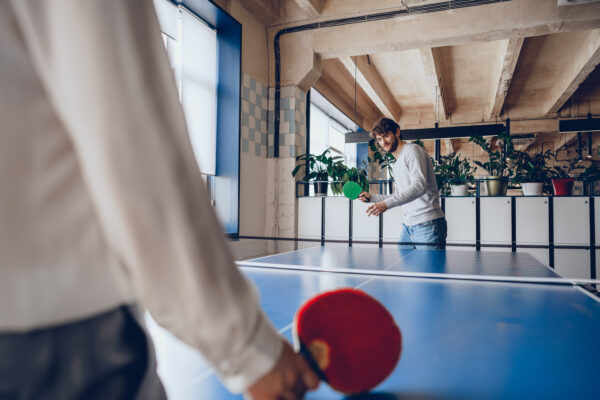Young people, man and woman playing table tennis indoors